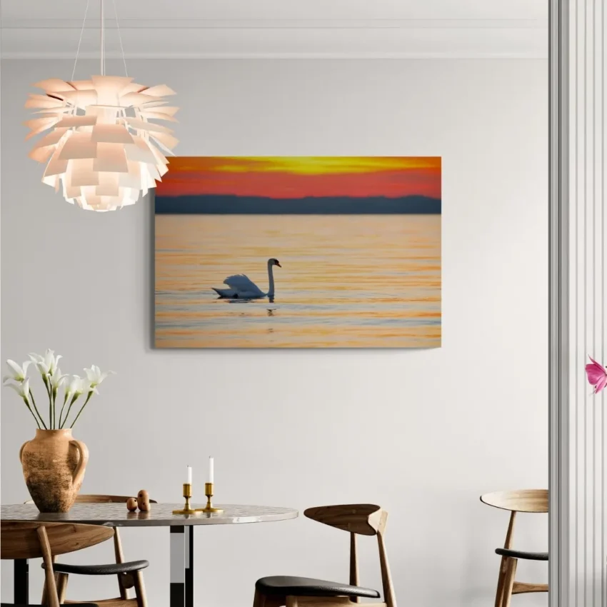Nature-themed gallery wraps canvas wall art of a serene white swan gliding on calm water during a vibrant orange and gold sunset capturing a peaceful and elegant atmosphere.