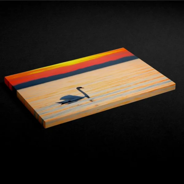 Nature-themed gallery wraps canvas wall art of a serene white swan gliding on calm water during a vibrant orange and gold sunset capturing a peaceful and elegant atmosphere.